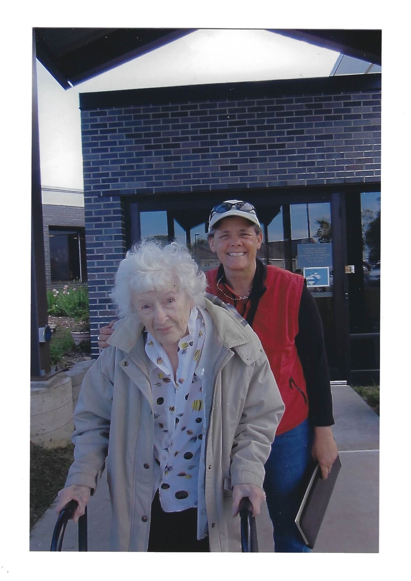 Two women are standing outside of a building.