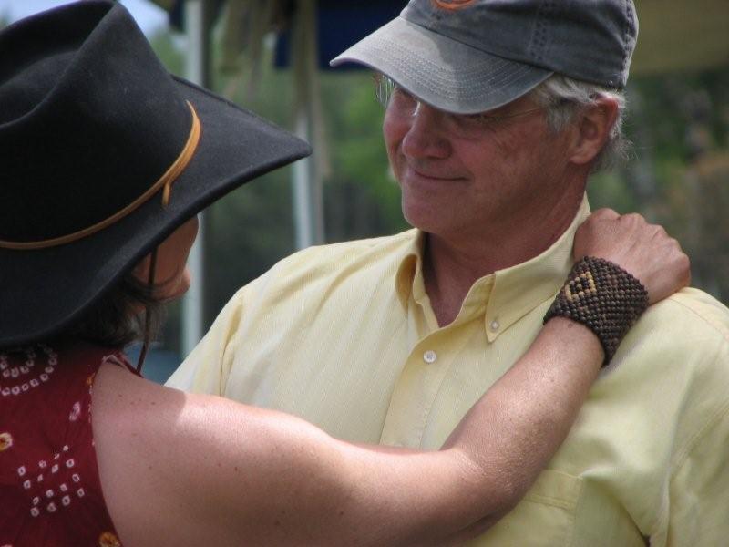 A man and woman are hugging outside.