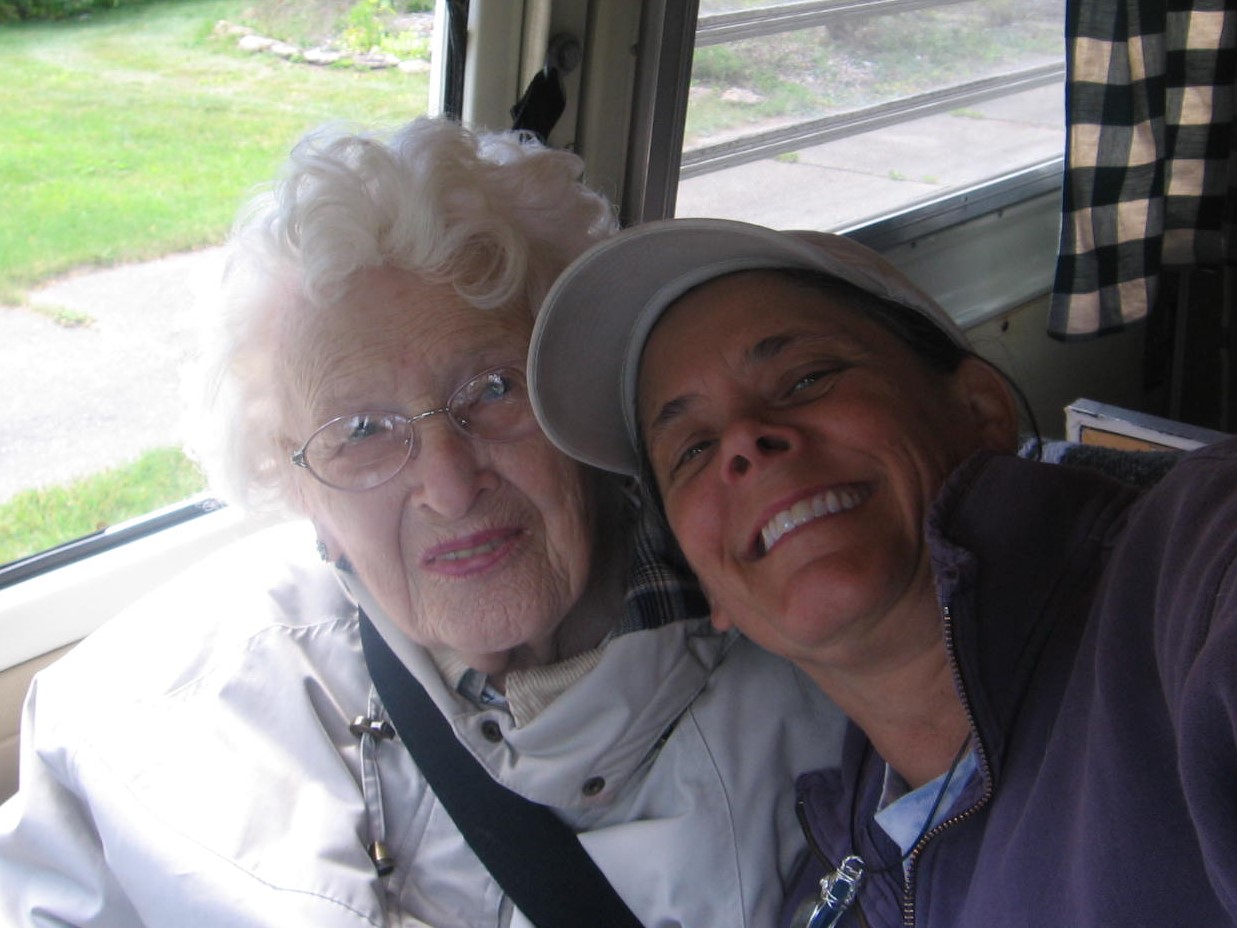 A woman and an old lady are smiling for the camera.