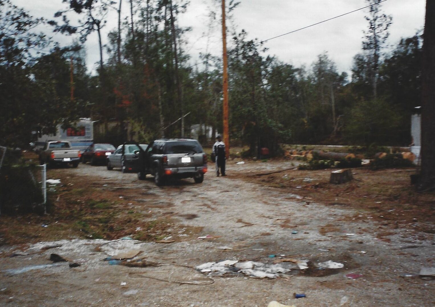 A man standing next to a car on the side of a road.