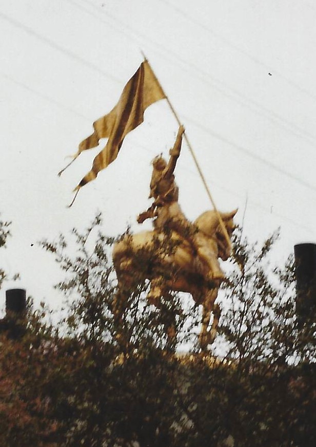 A man on horseback holding up a flag.