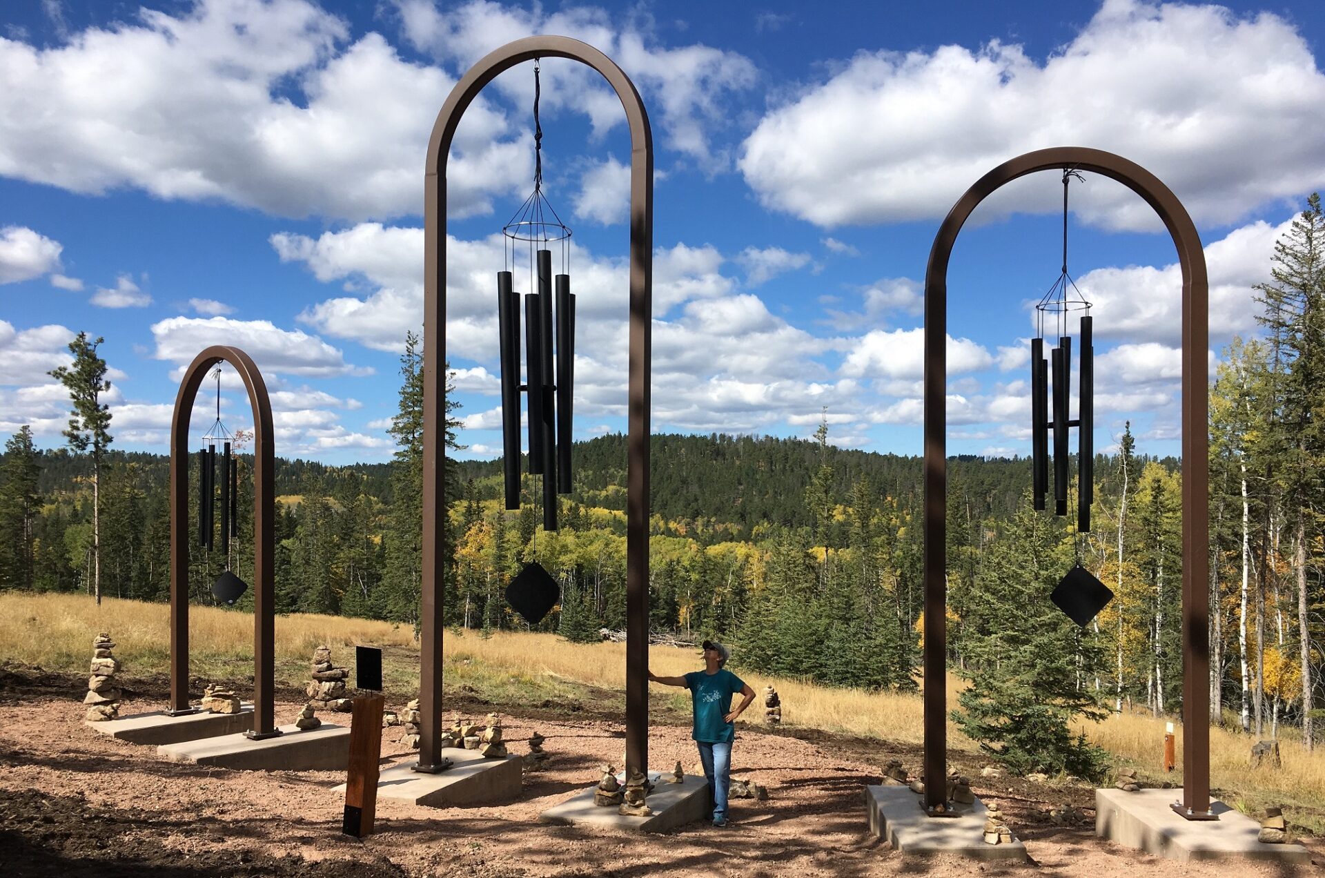 A person standing in front of some wind chimes.