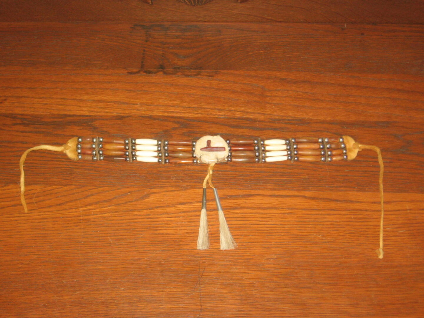 A wooden table with a white and brown bracelet on it