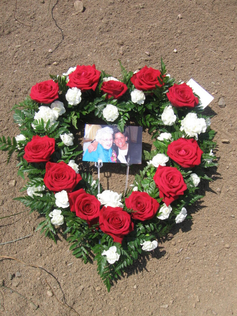 A heart shaped wreath of red and white roses.