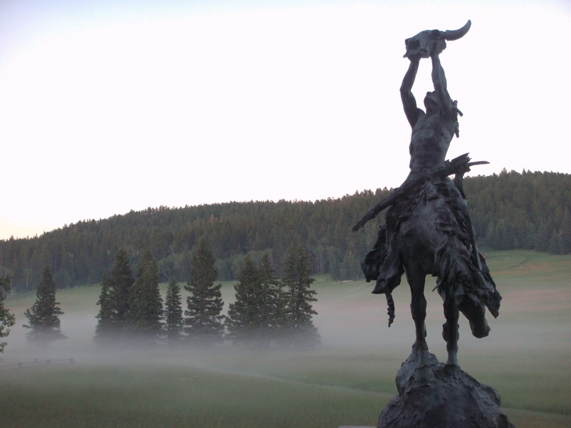 A statue of a man on horseback in the middle of a field.
