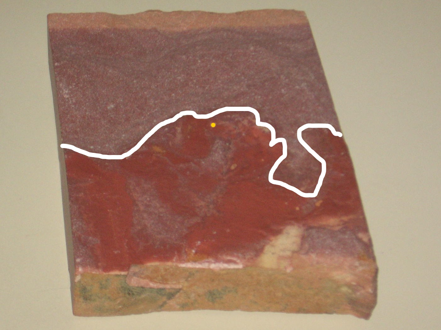 A piece of red cake with white lines on it.