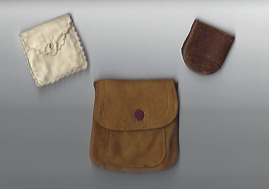 A brown bag next to two other bags.