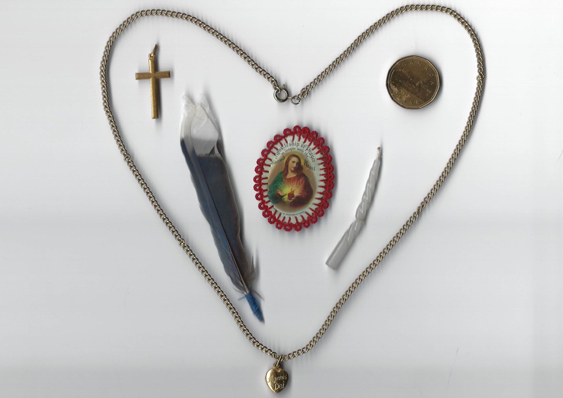A heart shaped necklace with various items on it.
