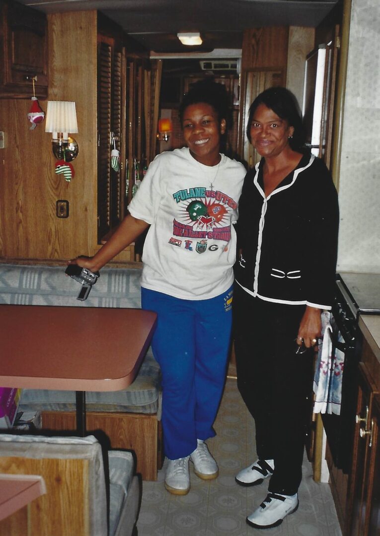 Two women standing in a kitchen next to each other.