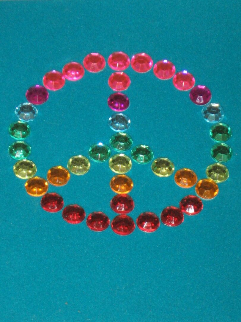 A peace sign made out of colored stones.