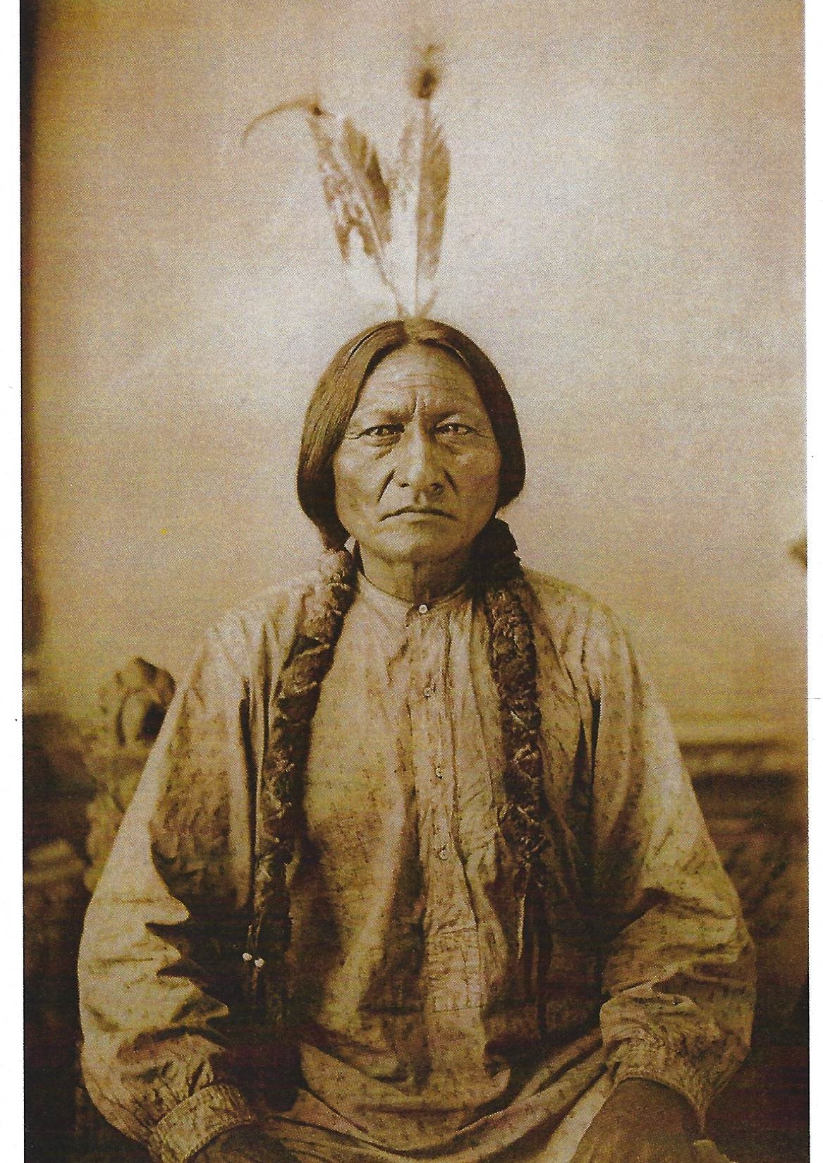 A man in native dress with feathers on his head.