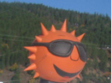 A sun with sunglasses on it's head.