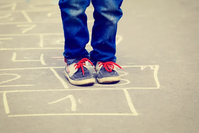 A person standing on the ground with their feet crossed.