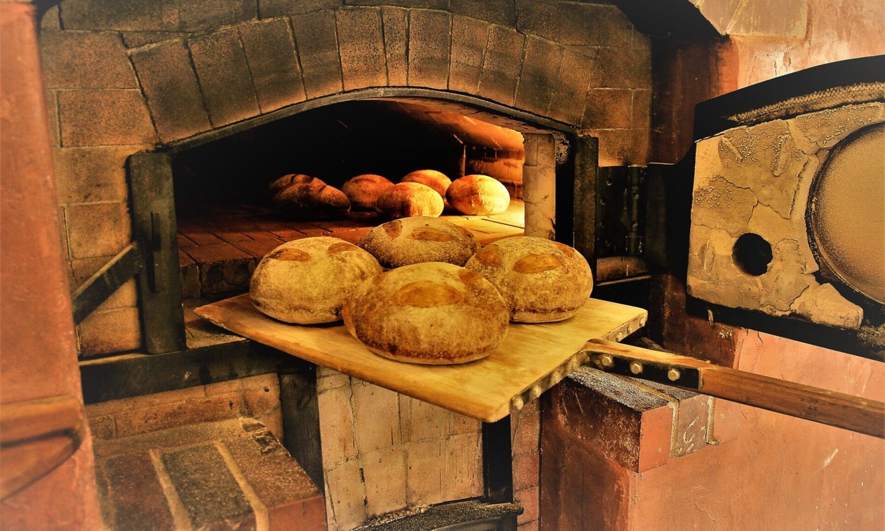 A wood fired oven with some bread on it