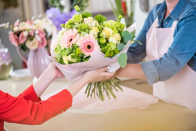 A person is handing flowers to another person.