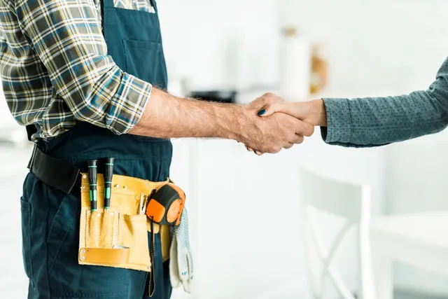 Two people shaking hands in a room.