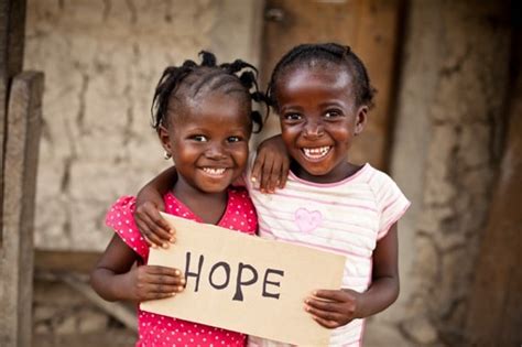 Two young girls holding a sign that says hope.