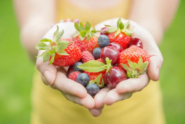 A person holding some fruit in their hands