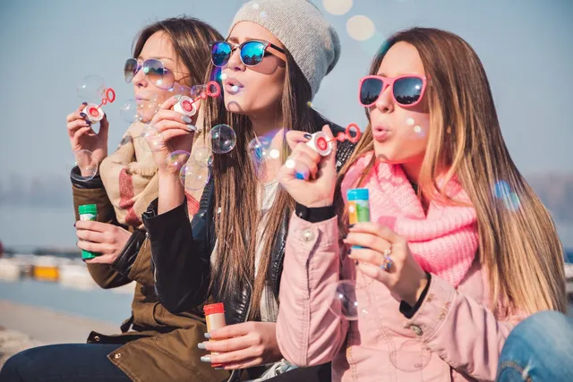 women blowing bubbles