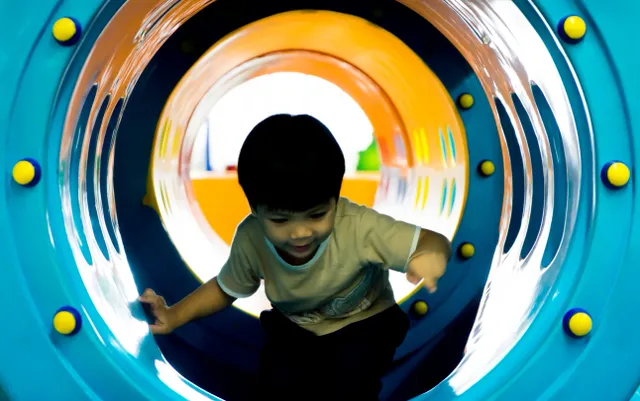 little boy in play tunnel