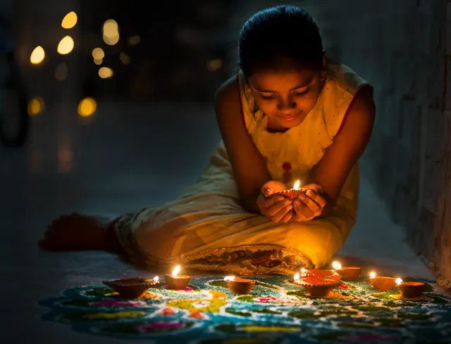 little girl holding a candle in devotion